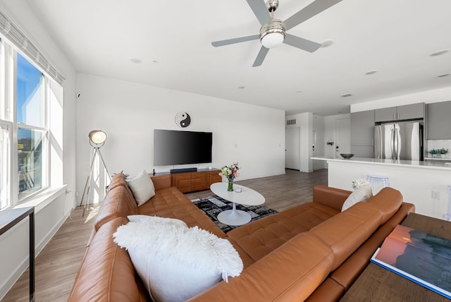 living area with visible vents, ceiling fan, and light wood-style flooring