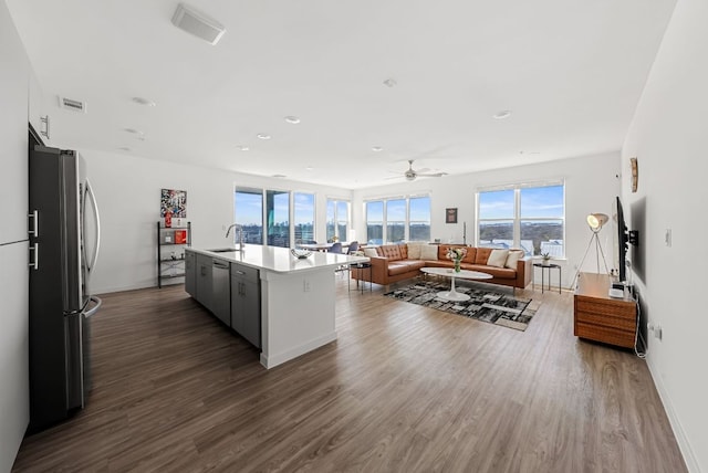 kitchen with freestanding refrigerator, dark wood finished floors, visible vents, and a sink