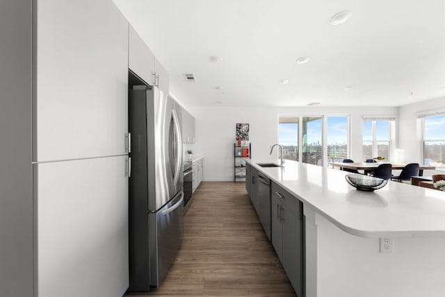 kitchen featuring light countertops, appliances with stainless steel finishes, modern cabinets, and a sink