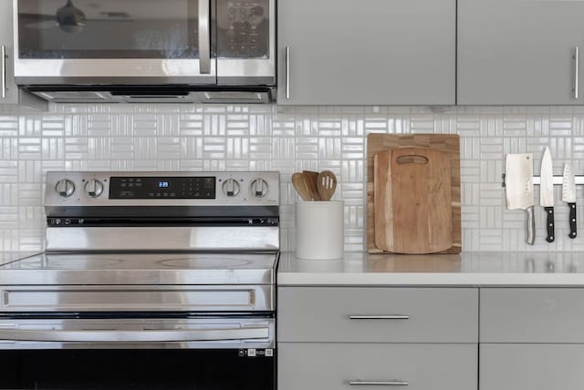 kitchen with stainless steel appliances, light countertops, white cabinetry, and tasteful backsplash