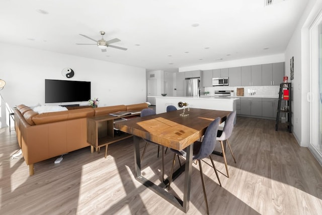 dining space featuring ceiling fan and light wood-type flooring