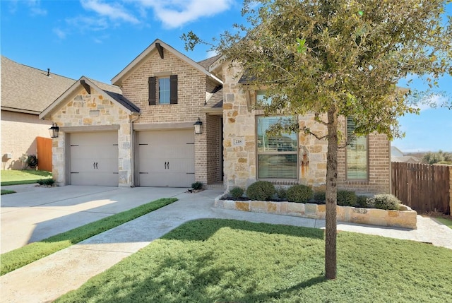 view of front facade with brick siding, concrete driveway, a front yard, fence, and stone siding