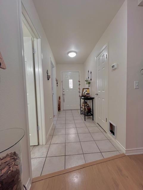 doorway to outside featuring visible vents, light wood-style flooring, and baseboards