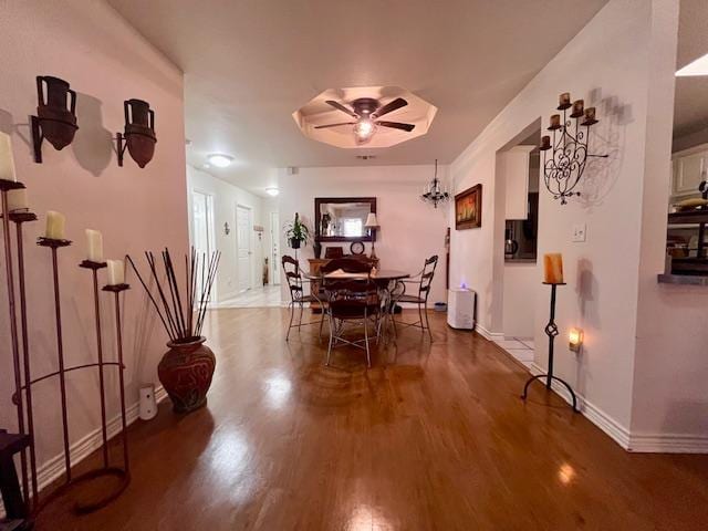 dining room featuring a ceiling fan, baseboards, and wood finished floors