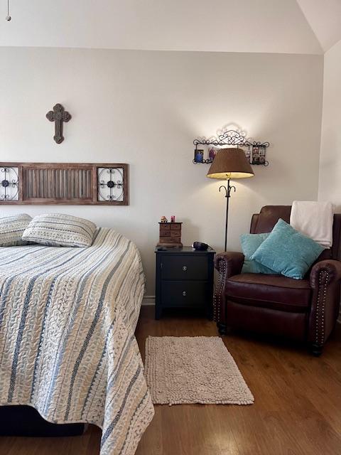 bedroom featuring lofted ceiling and wood finished floors