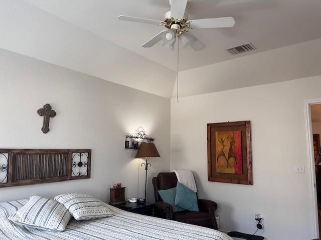 bedroom featuring lofted ceiling, visible vents, and a ceiling fan