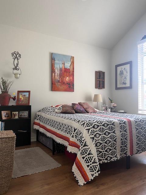 bedroom featuring lofted ceiling and wood finished floors