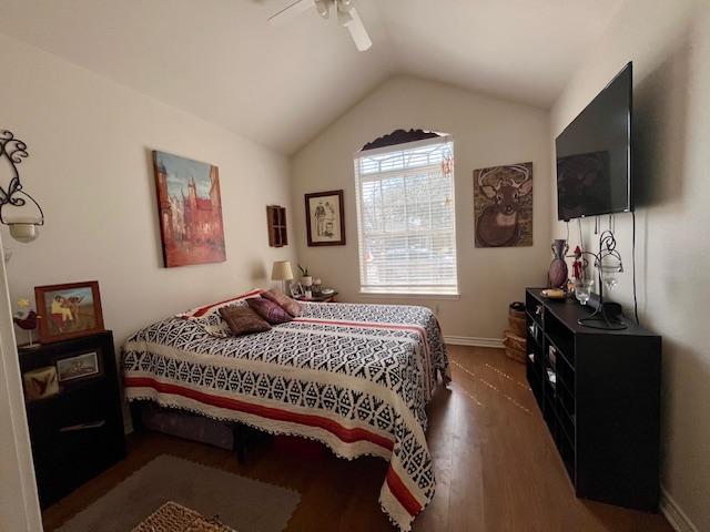 bedroom featuring lofted ceiling, ceiling fan, baseboards, and wood finished floors