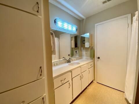 bathroom with vanity, visible vents, and tile patterned floors