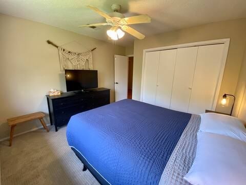 bedroom featuring carpet floors, a closet, and a ceiling fan