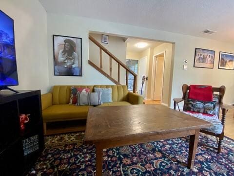 living area featuring stairs and wood finished floors