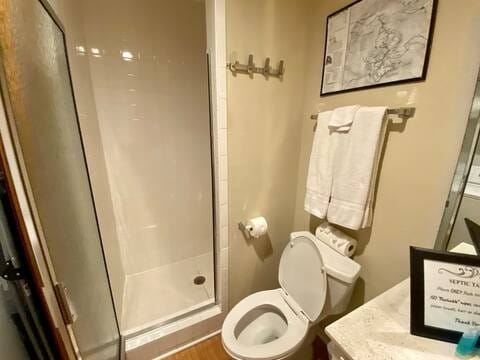 full bathroom with toilet and a stall shower