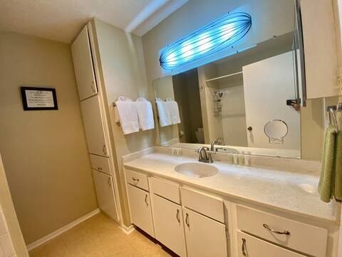 full bathroom featuring curtained shower, baseboards, and vanity