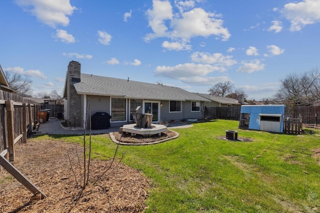 12810 Irongate Ave, Austin, TX 78727 - back of house featuring a chimney, a fenced backyard, an outbuilding, and an outdoor fire pit