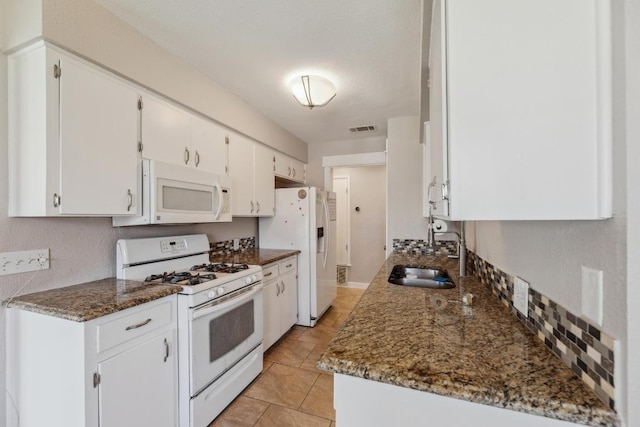 12810 Irongate Ave, Austin, TX 78727 - kitchen with white appliances, white cabinetry, and dark stone counters