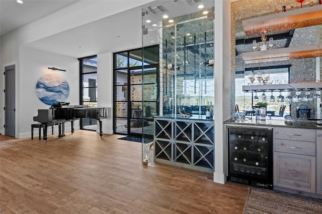 2923 Cliff Pt, Spicewood, TX 78669 - indoor wet bar featuring beverage cooler, wood finished floors, expansive windows, recessed lighting, and baseboards