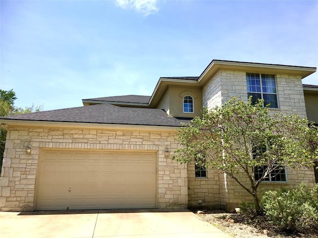 view of front facade with a garage, driveway, and roof with shingles