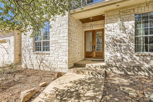 entrance to property featuring stone siding and french doors