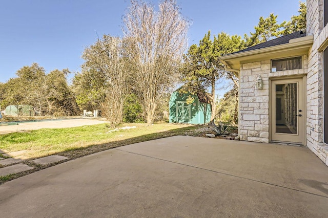 view of patio featuring an outbuilding and a storage unit