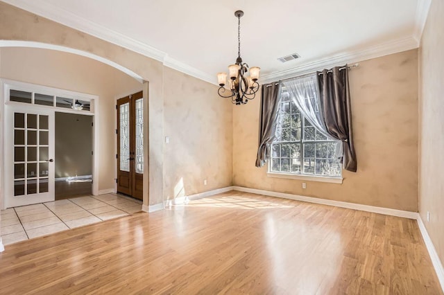 210 Amandas Way, Leander, TX 78641 - empty room with french doors, a chandelier, wood finished floors, arched walkways, and ornamental molding