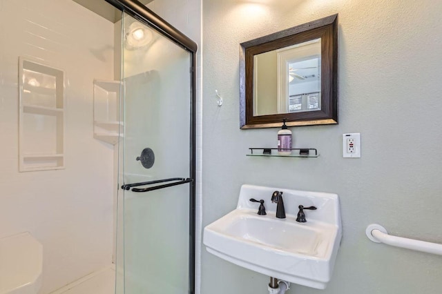 full bathroom with a stall shower and a sink