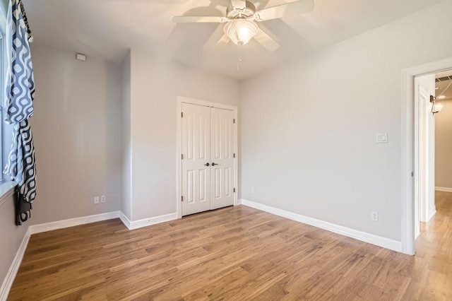 unfurnished bedroom with ceiling fan, light wood finished floors, a closet, and baseboards