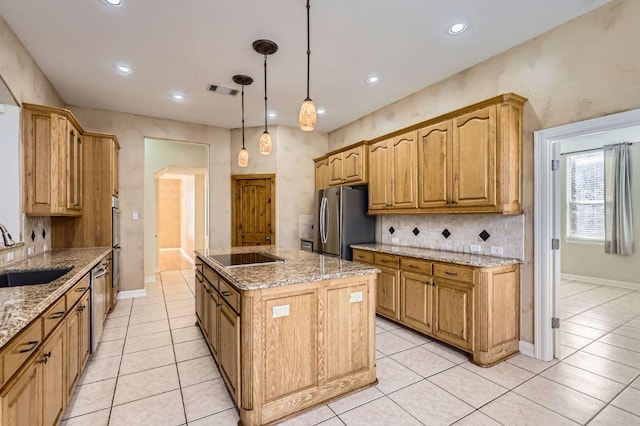 kitchen featuring light tile patterned floors, stainless steel appliances, tasteful backsplash, a kitchen island with sink, and a sink