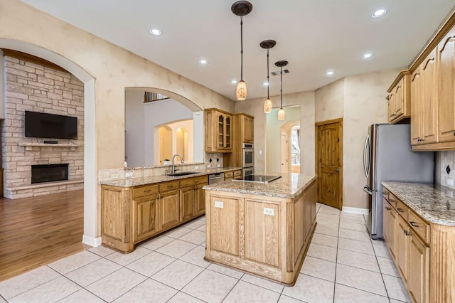 210 Amandas Way, Leander, TX 78641 - kitchen with a center island, appliances with stainless steel finishes, glass insert cabinets, light tile patterned floors, and recessed lighting