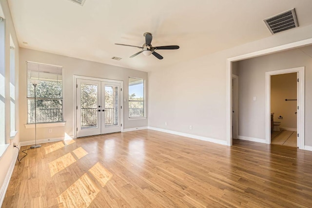 unfurnished room with light wood-style floors, baseboards, visible vents, and french doors