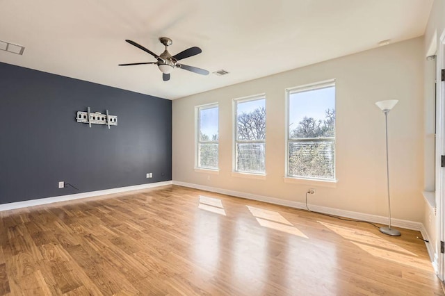 spare room with visible vents, light wood-style flooring, and baseboards