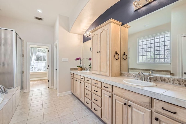 210 Amandas Way, Leander, TX 78641 - bathroom featuring double vanity, a shower stall, tile patterned floors, tiled bath, and recessed lighting