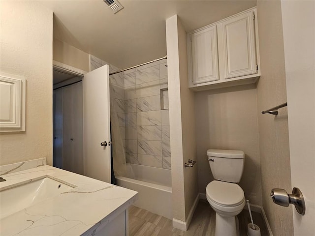 full bath featuring visible vents, toilet, washtub / shower combination, vanity, and baseboards