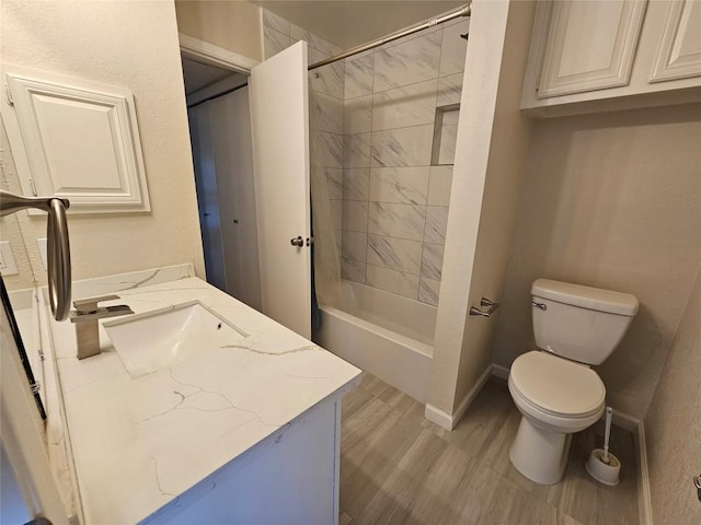 bathroom with bathtub / shower combination, baseboards, vanity, and toilet