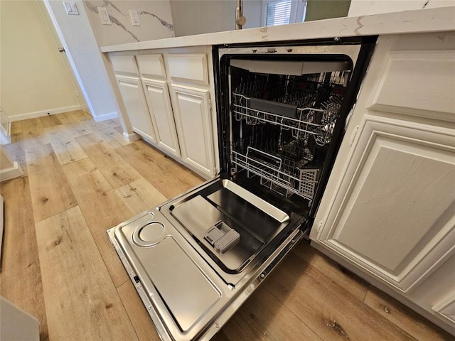 kitchen featuring light wood-style flooring, baseboards, white cabinets, and light countertops