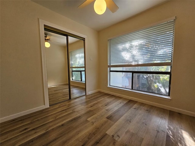 unfurnished room featuring ceiling fan, baseboards, and wood finished floors