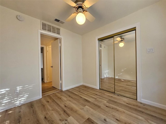 unfurnished bedroom featuring wood finished floors, visible vents, and baseboards