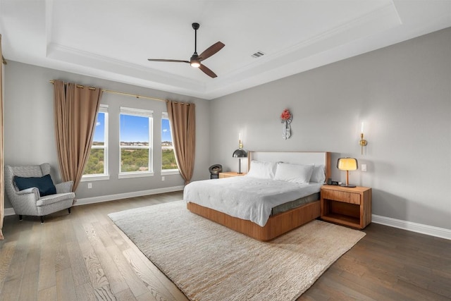 2201 Bel Paese Bnd, Leander, TX 78641 - bedroom featuring ceiling fan, visible vents, a raised ceiling, baseboards, and hardwood / wood-style floors