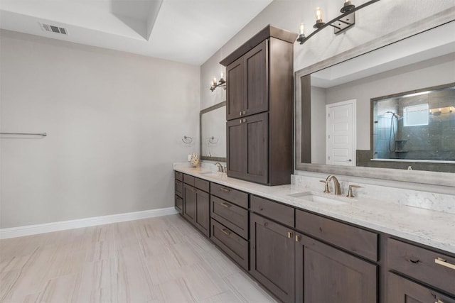 2201 Bel Paese Bnd, Leander, TX 78641 - bathroom featuring visible vents, a sink, a tile shower, and double vanity