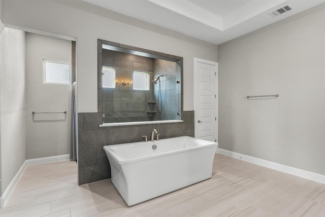 2201 Bel Paese Bnd, Leander, TX 78641 - bathroom with baseboards, plenty of natural light, tiled shower, and visible vents