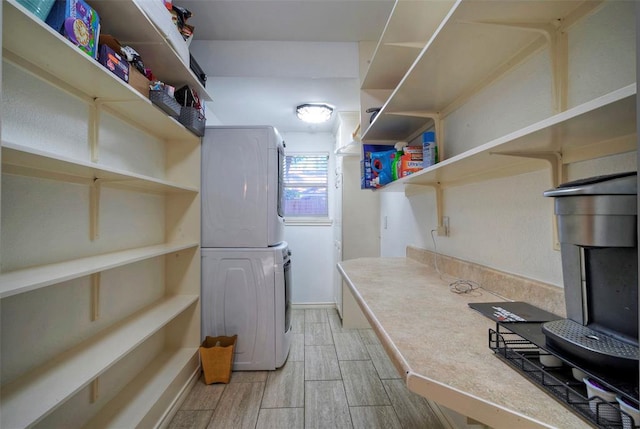 washroom featuring laundry area, wood tiled floor, and stacked washer / dryer