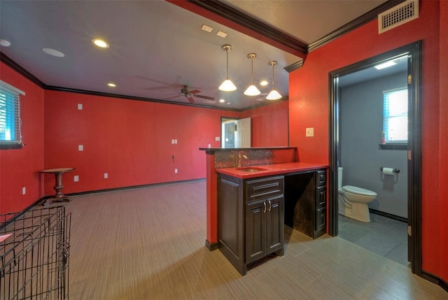 bar featuring crown molding, pendant lighting, visible vents, and a sink