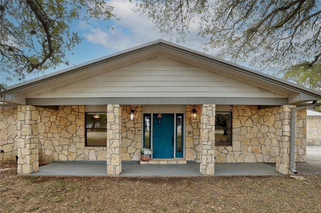 view of front of house with stone siding and a porch