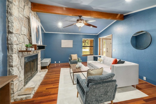 living room with crown molding, vaulted ceiling with beams, a stone fireplace, and wood finished floors