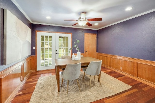 dining room with wainscoting, ornamental molding, wood finished floors, and french doors