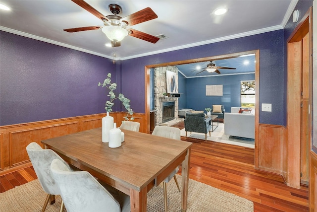 dining room with a wainscoted wall, visible vents, and ornamental molding