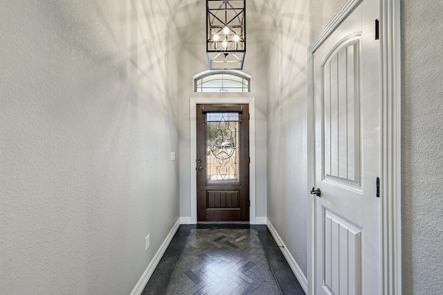 entryway featuring a textured wall and baseboards