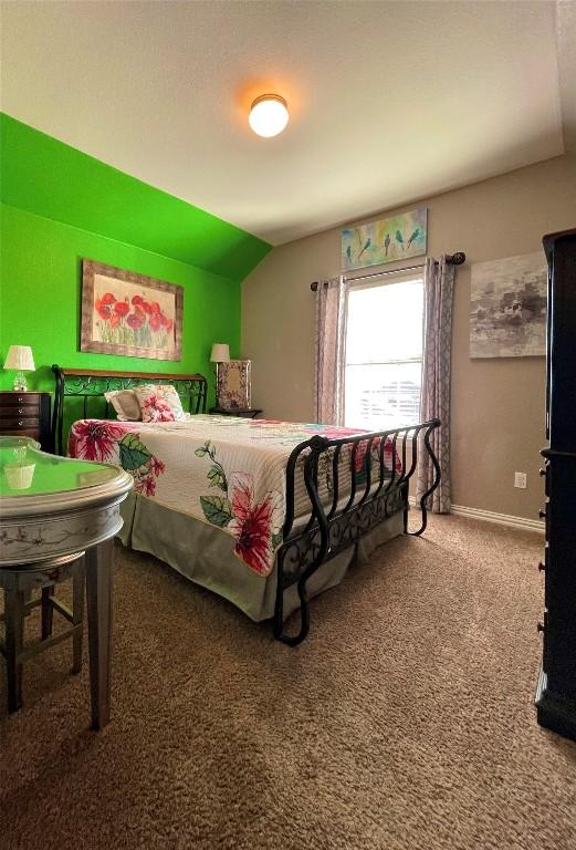 bedroom with carpet, lofted ceiling, and baseboards