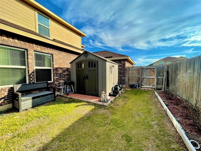 view of yard featuring a shed, a fenced backyard, and an outdoor structure