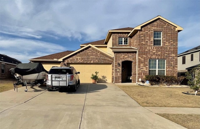 view of front facade with a garage, brick siding, and driveway