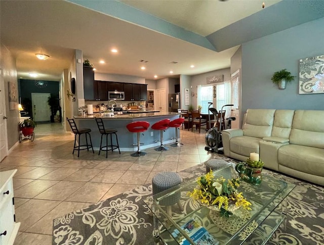 living area featuring light tile patterned flooring, baseboards, and recessed lighting
